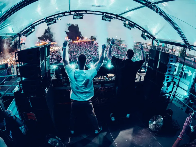 NOX Stage beim Ikarus Festival 2026 — Weitwinkel von hinter dem DJ-Pult über das Publikum